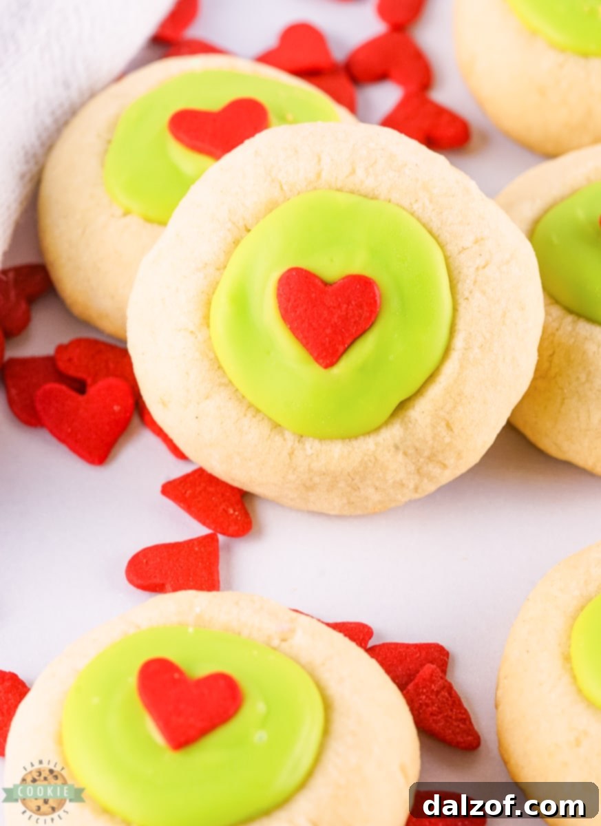Close-up of vibrant green Grinch Thumbprint Cookies ready for baking.
