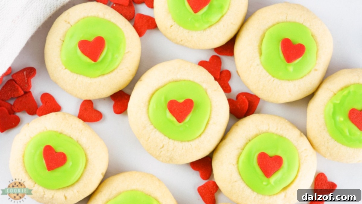 Freshly baked Grinch Thumbprint Cookies cooling on a wire rack.