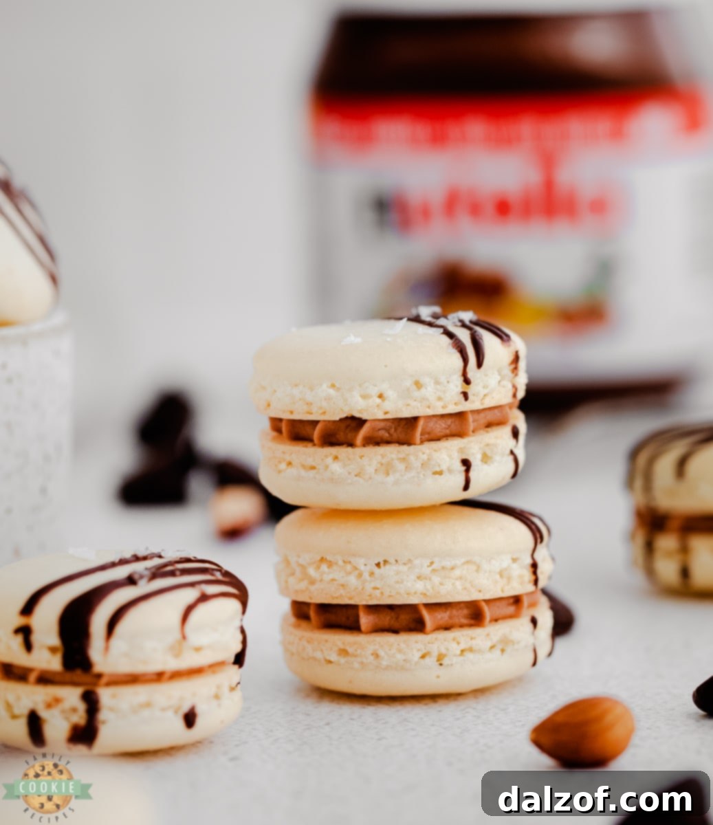 Delicate Nutella macarons with chocolate drizzle on a baking sheet
