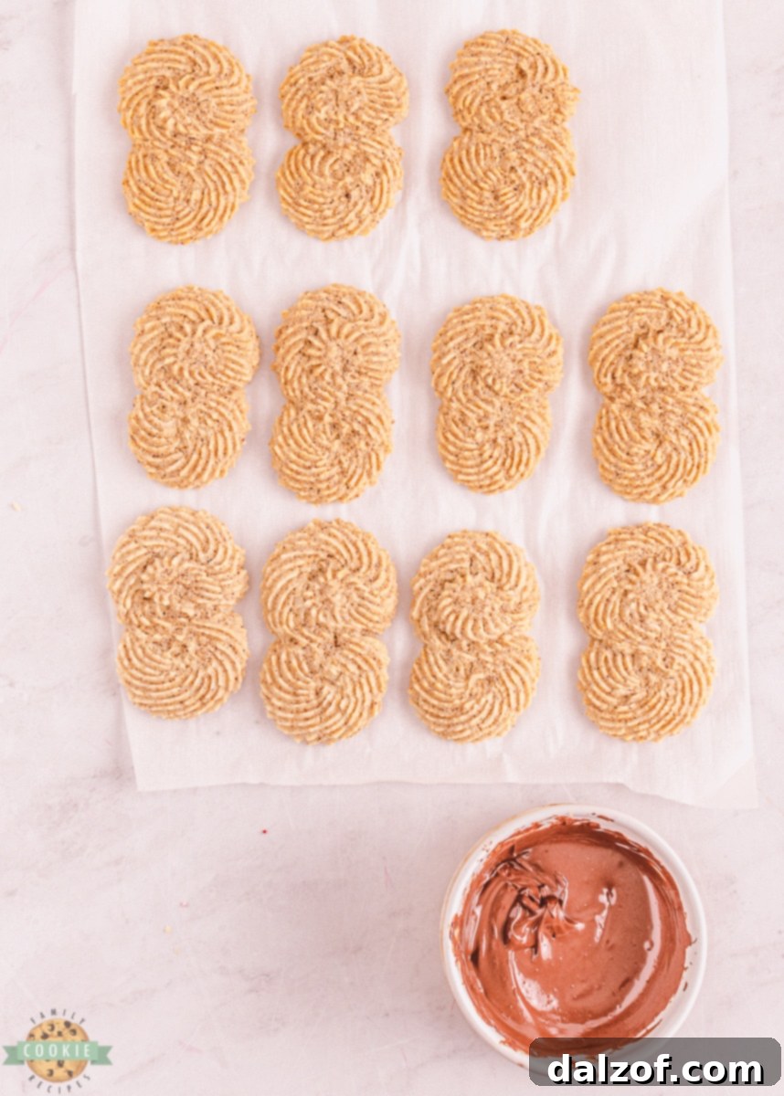 Espresso butter cookies neatly arranged on a cooling rack, some already dipped in chocolate.