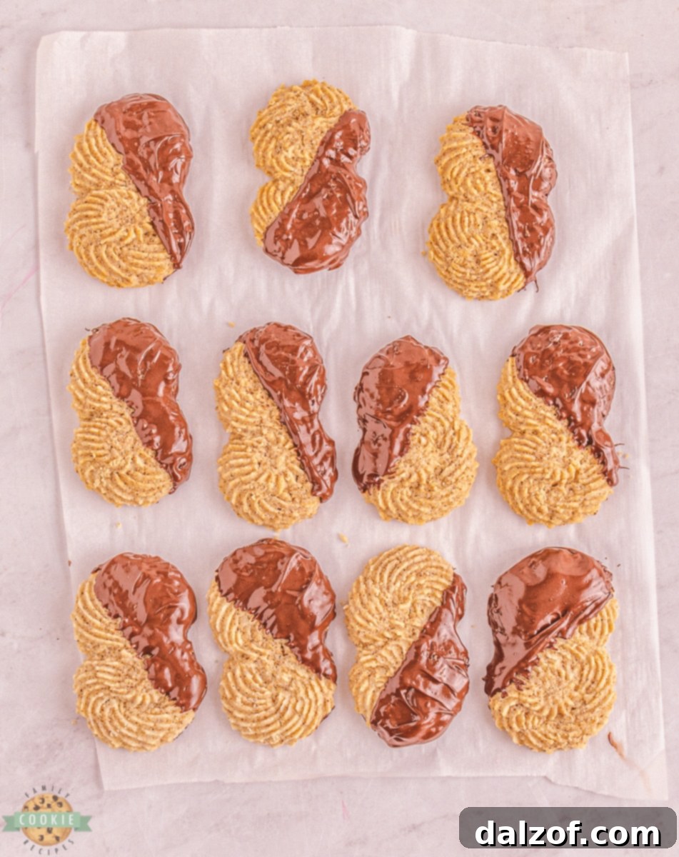 Hands piping S-shaped espresso butter cookie dough onto a baking sheet.