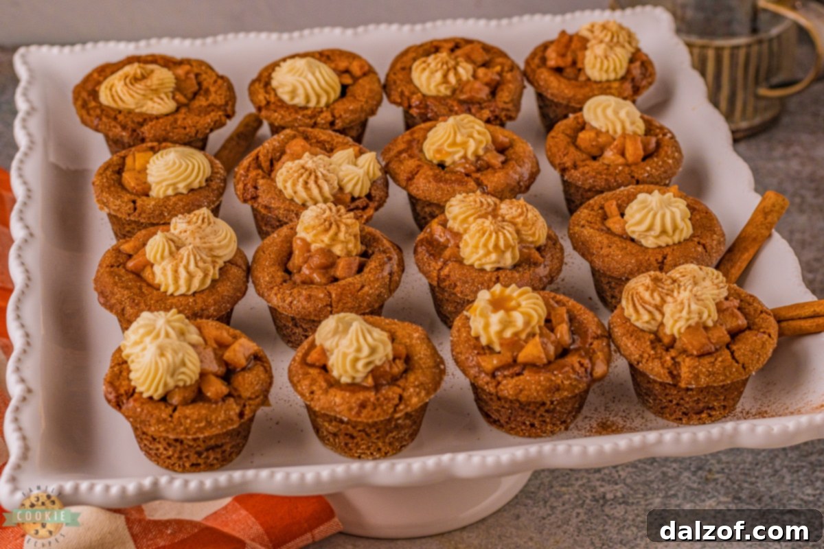 Baked gingerbread cookie cups cooling in a mini muffin pan, ready for their apple filling