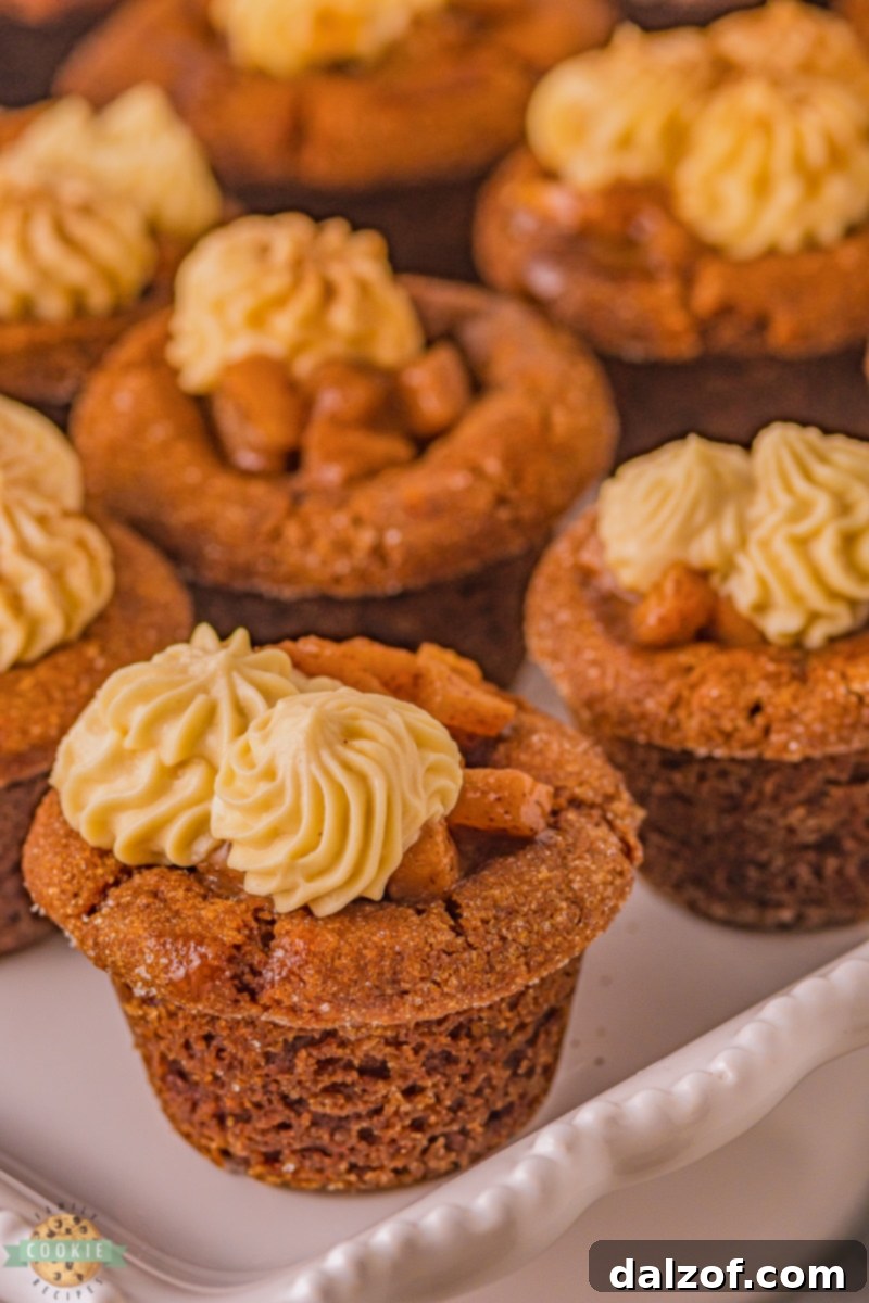 Gingerbread cookie cups baked and shaped, cooling in a mini muffin pan