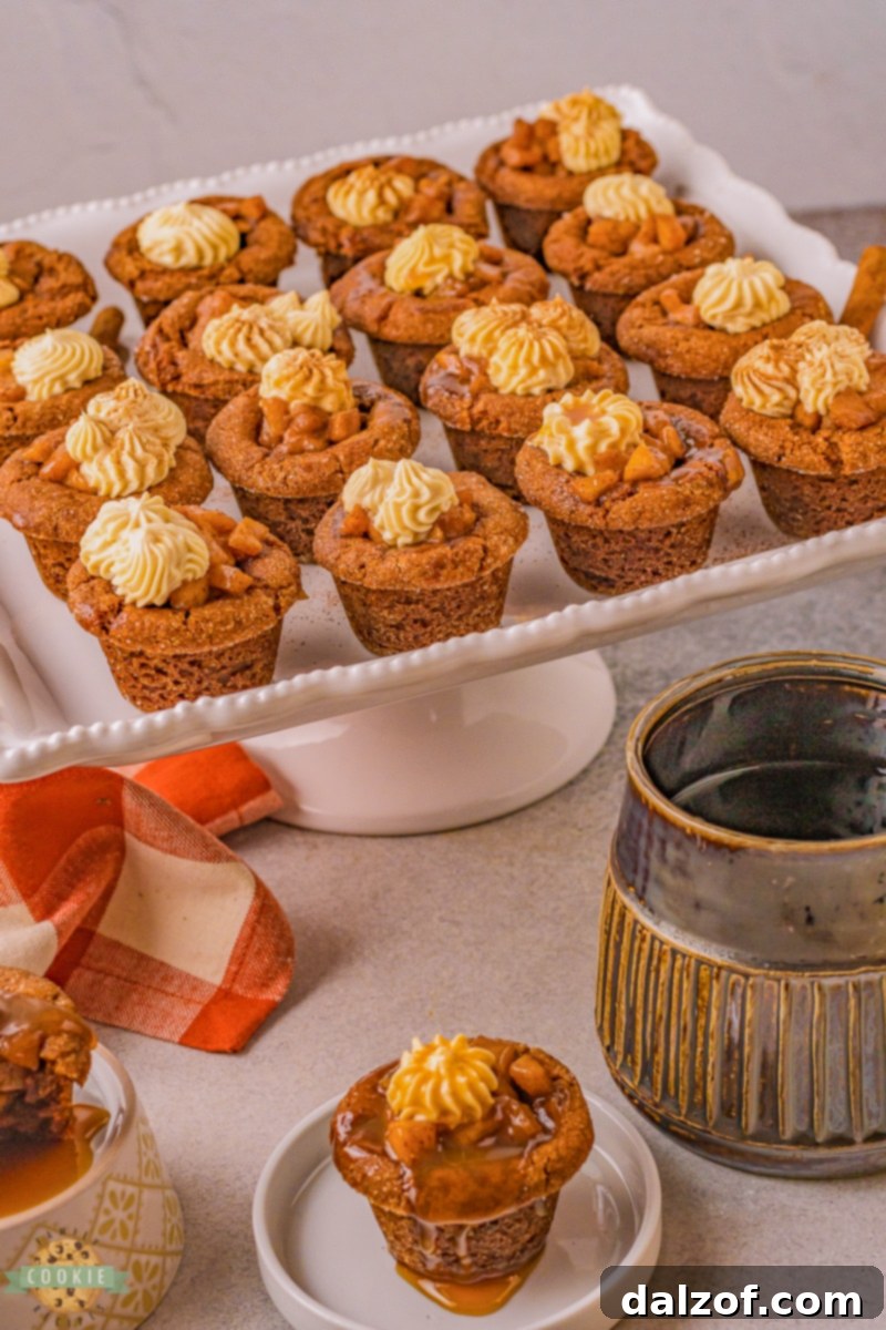 A tray of beautifully arranged caramel apple gingerbread cookies with creamy frosting and caramel drizzle