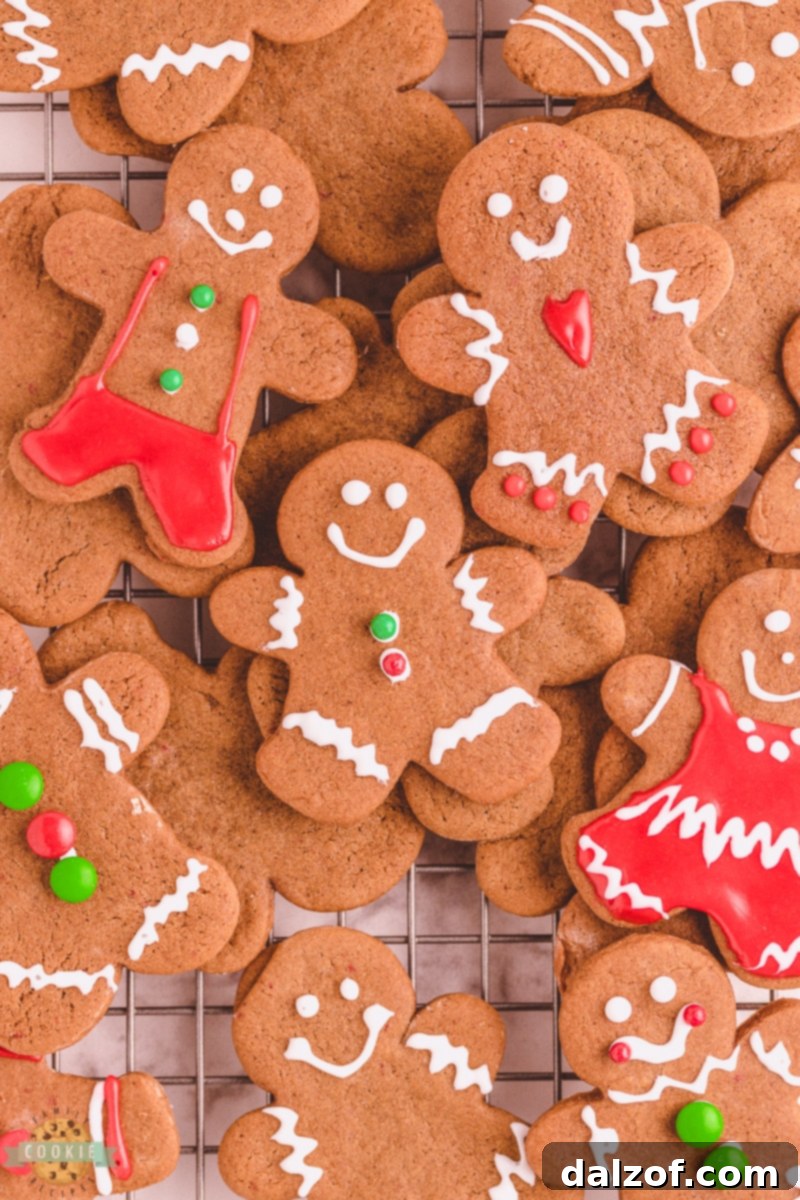 Decorated gingerbread cookies piled neatly on a wire cooling rack, showcasing various festive designs.