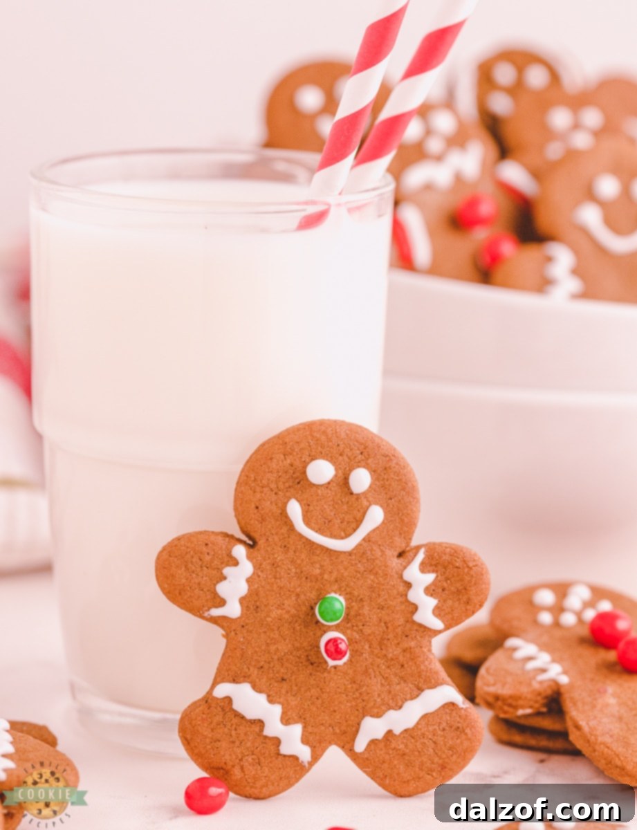 A charming gingerbread boy cookie sitting beside a tall glass of fresh milk, ready for a delicious snack.