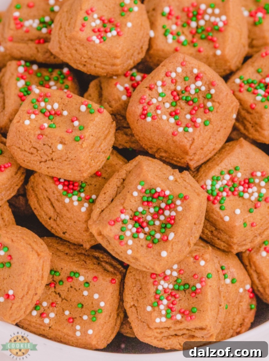 A baking pan filled with gingerbread cookie dough, pressed flat and topped with colorful nonpareil sprinkles, ready for chilling.