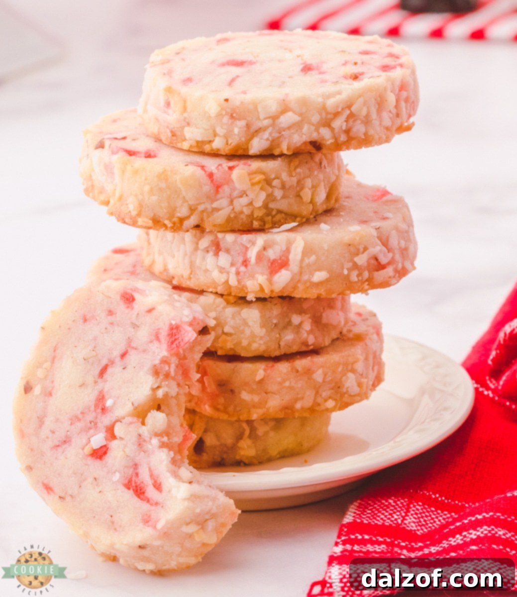 Close-up of baked Santa's Whiskers Cookies showing the coconut coating, cherry pieces, and pecan nuts.