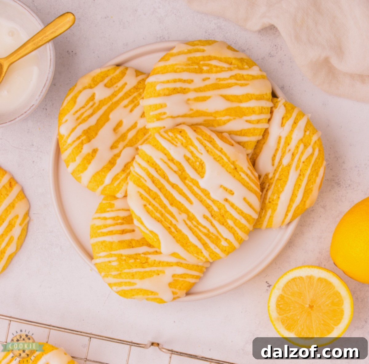 Freshly baked soft lemon cookies cooling on a wire rack, ready for glazing.