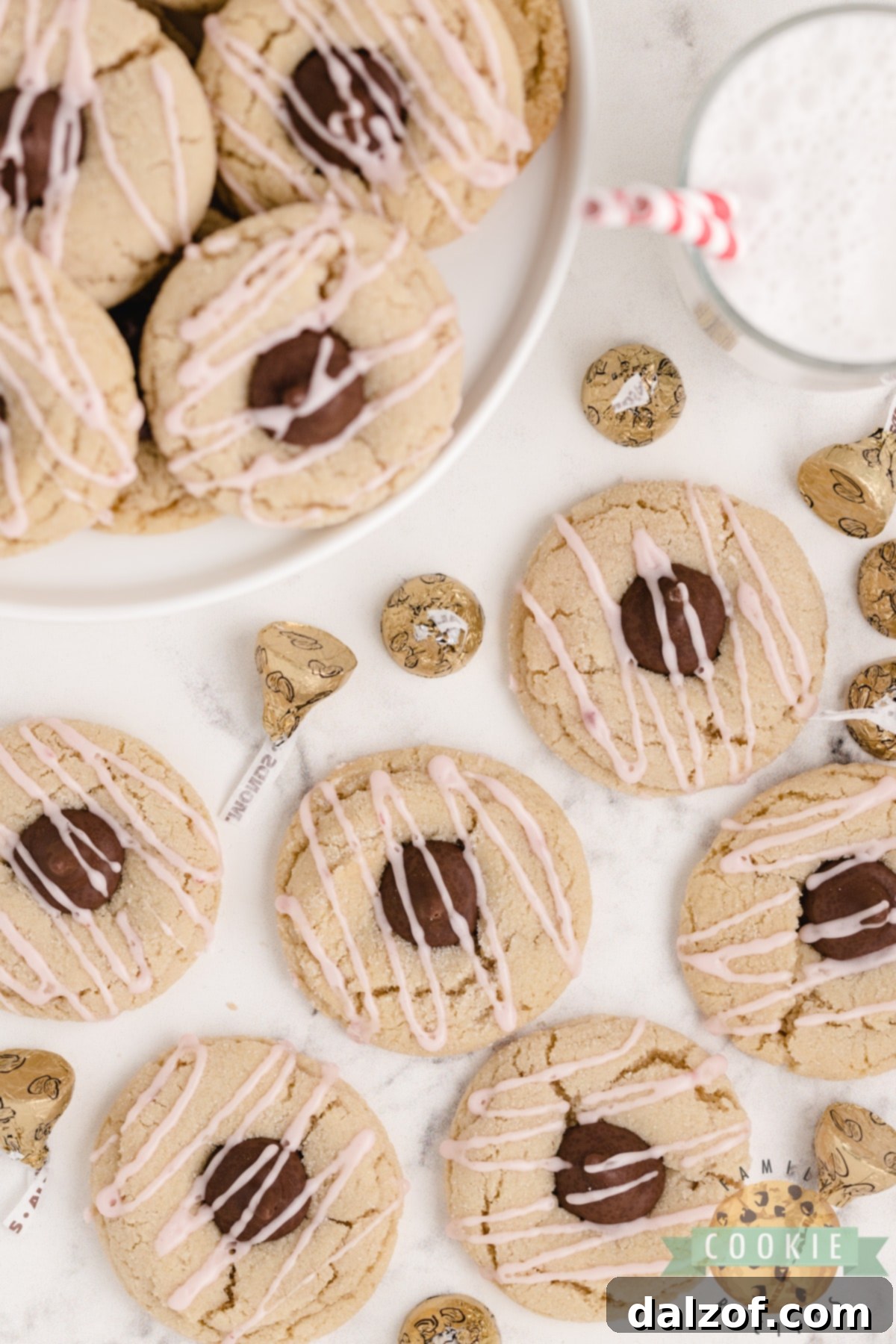 Almond Kiss Cookies made with almond extract and Hershey kisses with almonds! Drizzled with a simple raspberry glaze, these make a fantastic alternative to the traditional peanut butter blossoms!