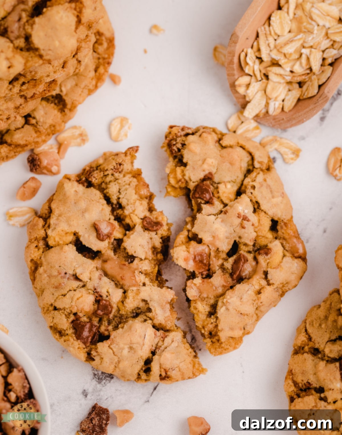 oatmeal toffee cookie broken in half, showing internal texture and toffee bits