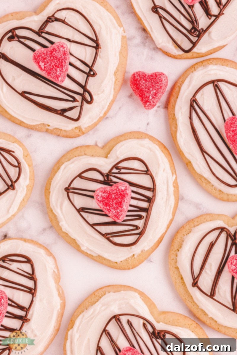 heart sugar cookies with icing, a chocolate heart and a candy heart, displayed on a charming pink plate for Valentine's Day.