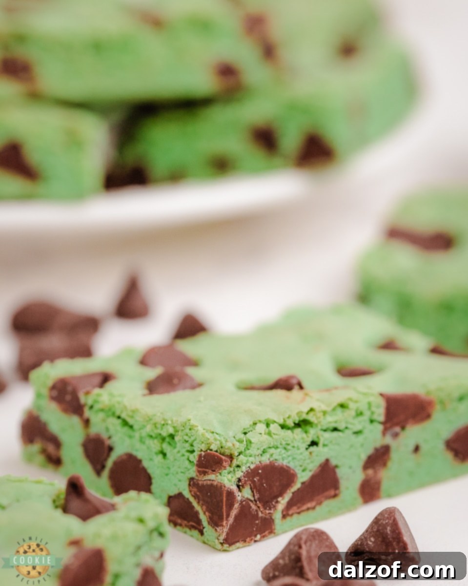 Stack of freshly baked mint chocolate chip cookie bars, showing their soft interior