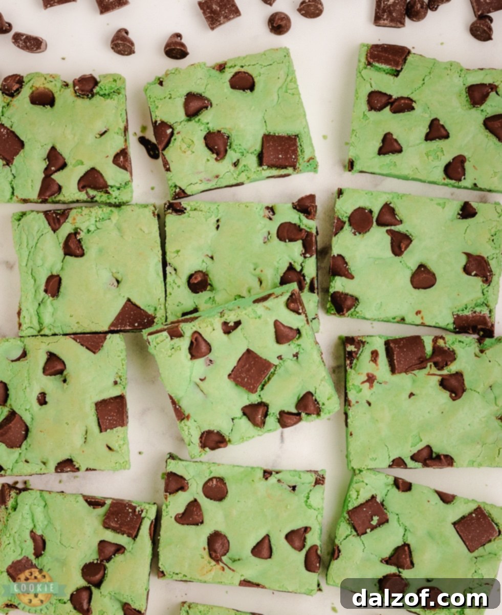 Green mint chocolate chip cookie bars cut into perfect squares on a white platter