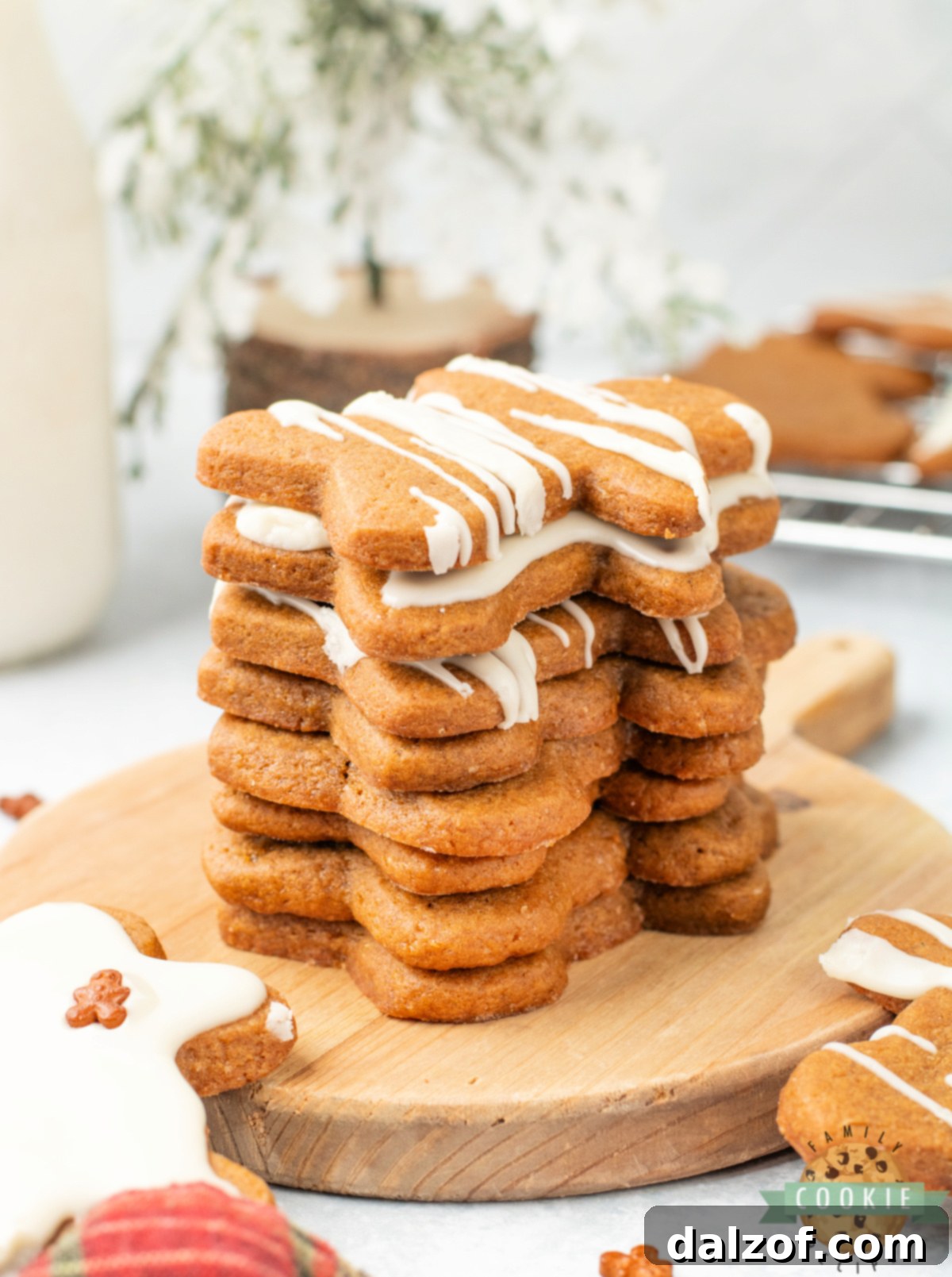 A charming stack of homemade gingerbread cookies generously coated with smooth maple icing, a perfect festive treat.