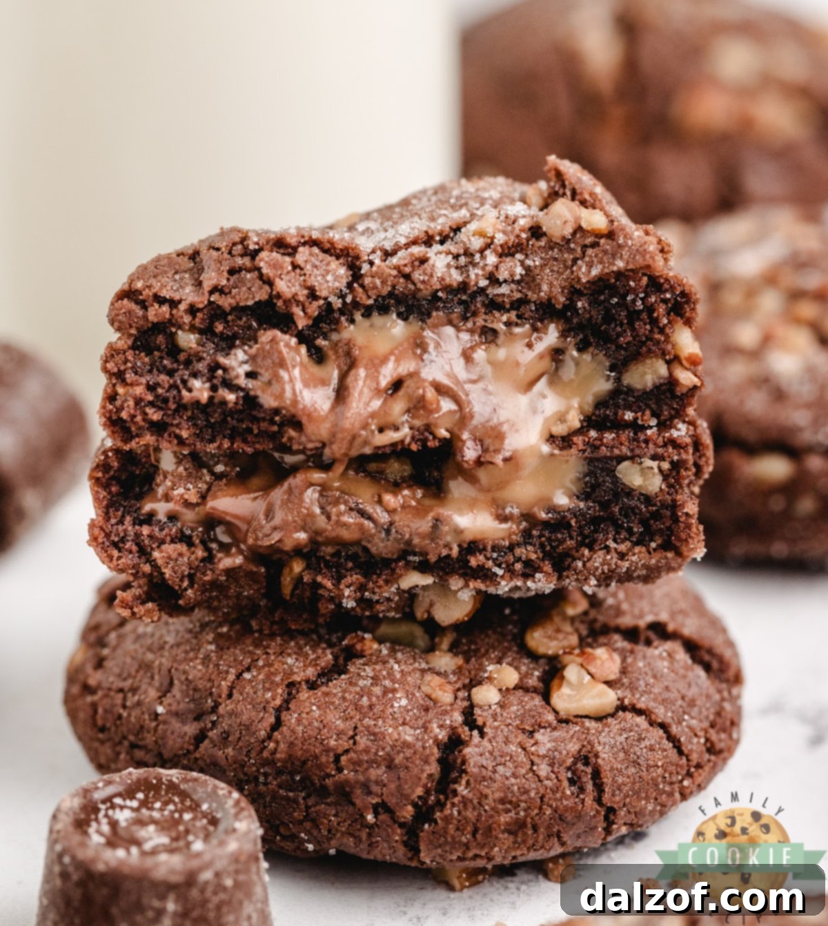 Decadent Chocolate Caramel Pecan Cookies 2 Stack of chocolate caramel pecan cookies with gooey caramel oozing from the center.