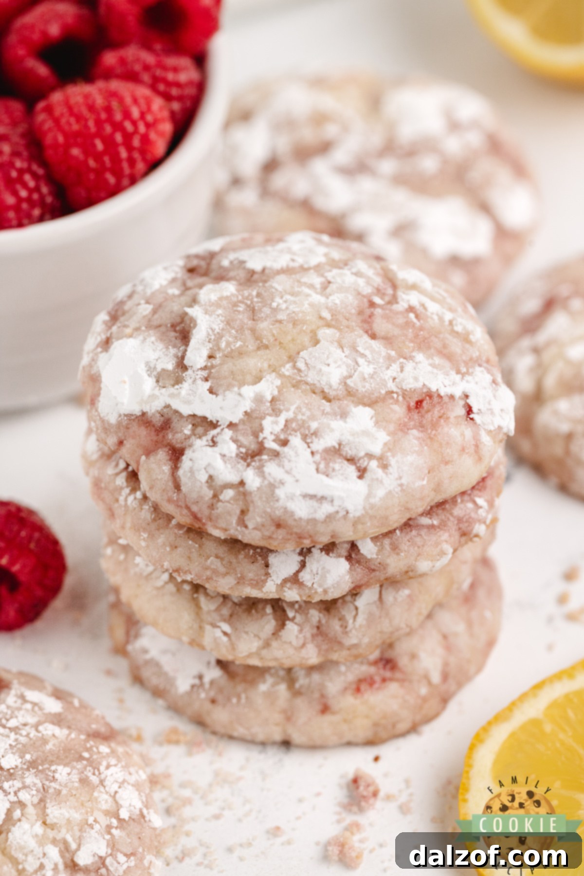 Bakery-style lemon raspberry crinkle cookies stacked in a pile.