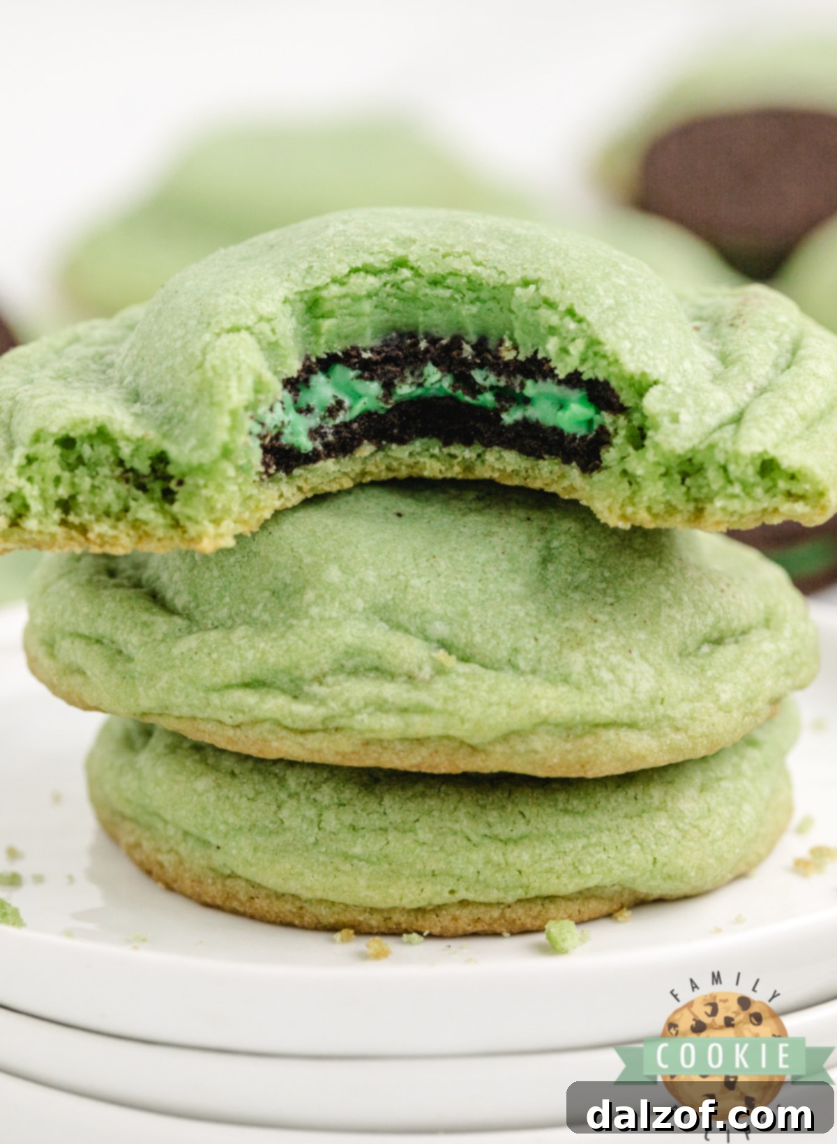 Mint Oreo stuffed cookies stacked on a plate showing the Oreo center.