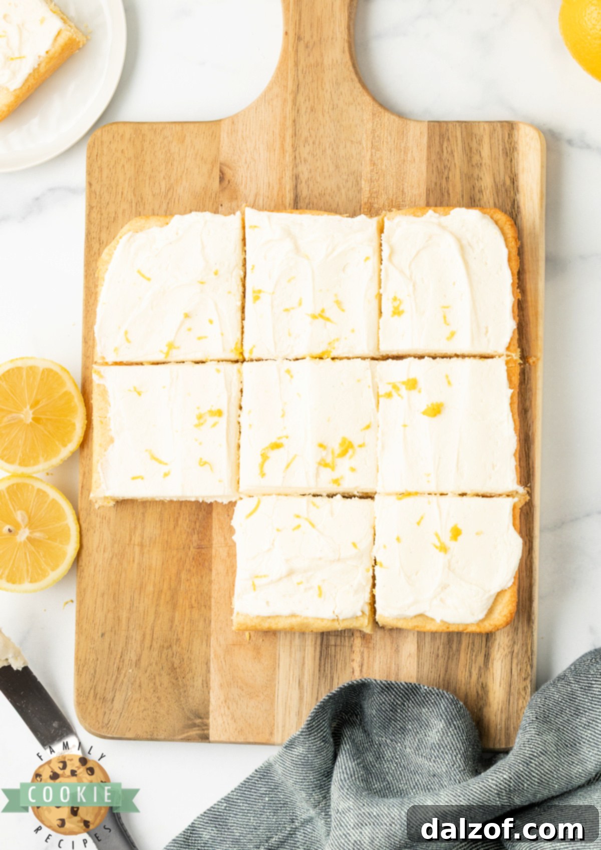 Lemon cookie bars being cut into squares with a knife.