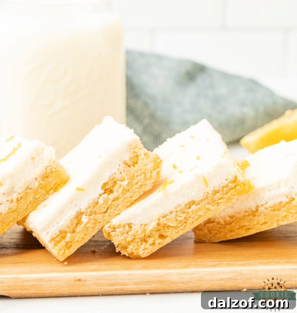 Lemon cookie bars cut into squares and topped with cream cheese frosting.