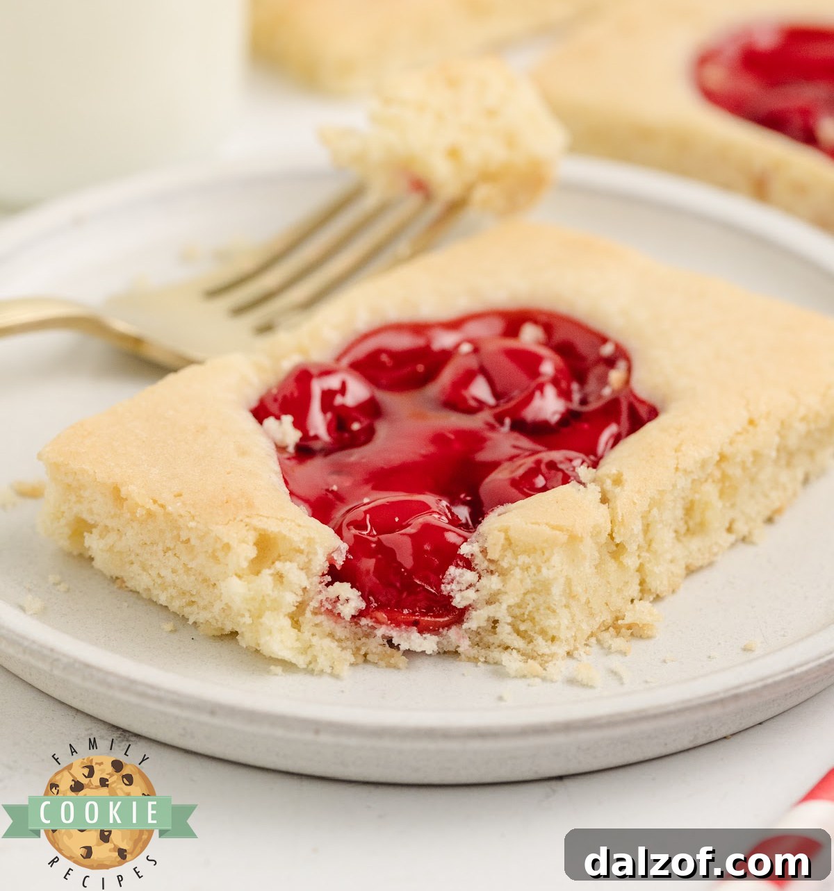 Close-up of a cherry pie cookie bar showing the soft buttery base and sweet cherry pie filling on top.