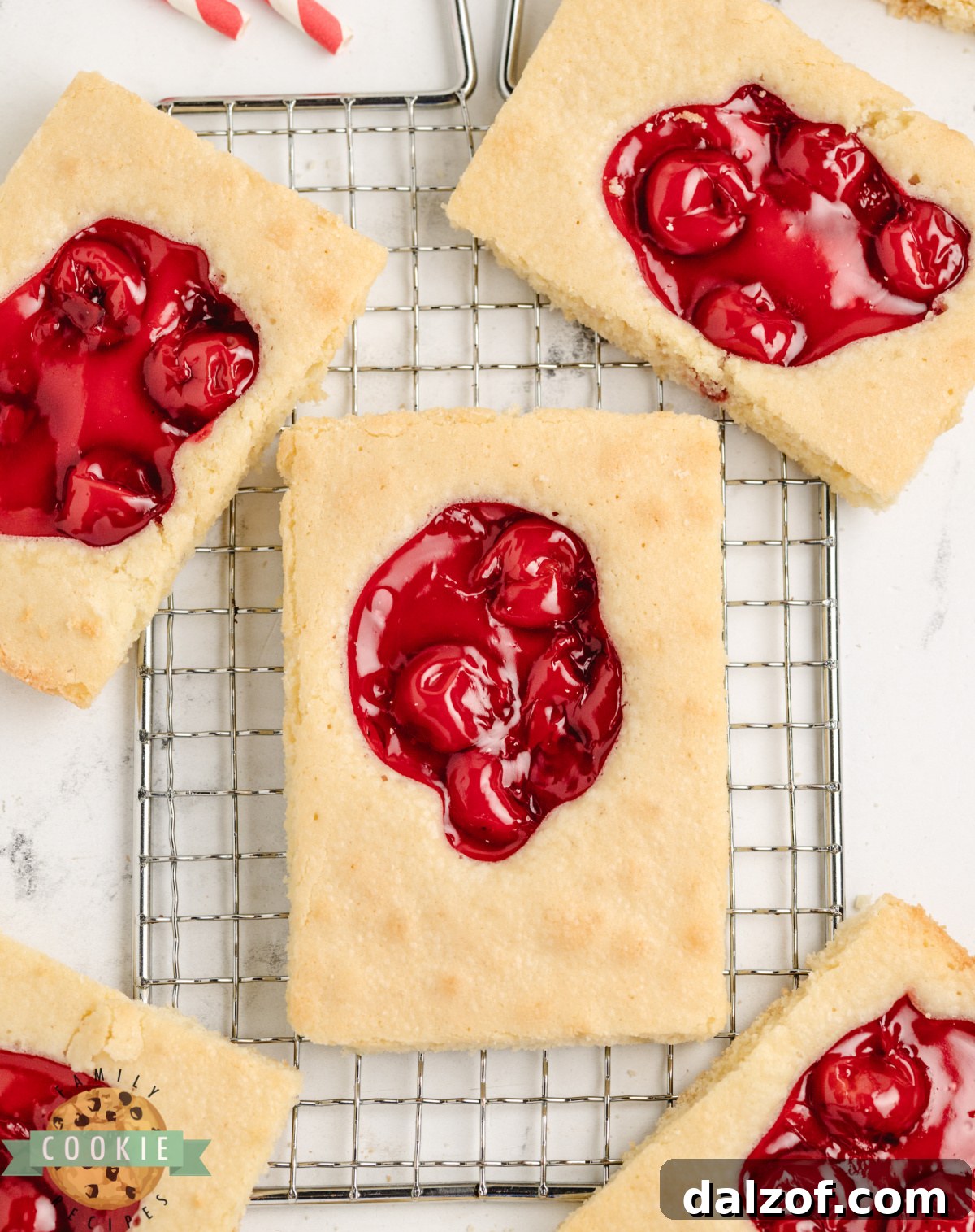 Overhead view of cherry pie cookie bars on a wire rack cut into squares with cherry topping.