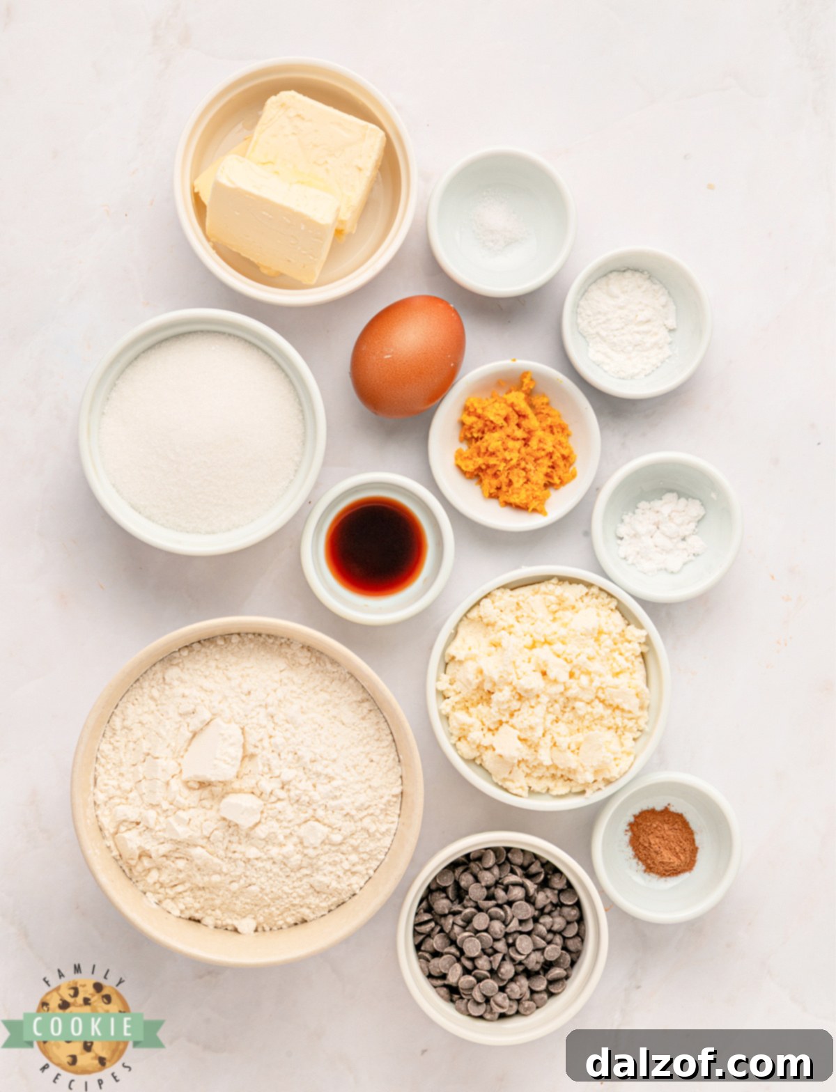 Ingredients for soft cannoli cookies, including flour, sugar, butter, ricotta, and chocolate chips, arranged on a surface.