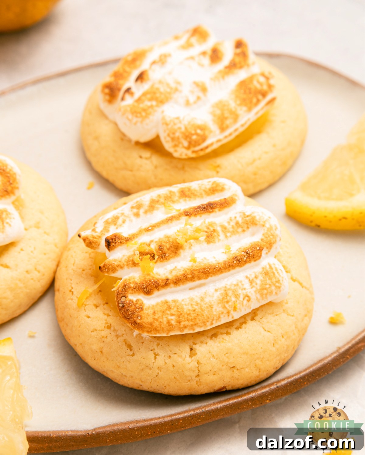 Lemon meringue pie cookies topped with toasted meringue on a platter.