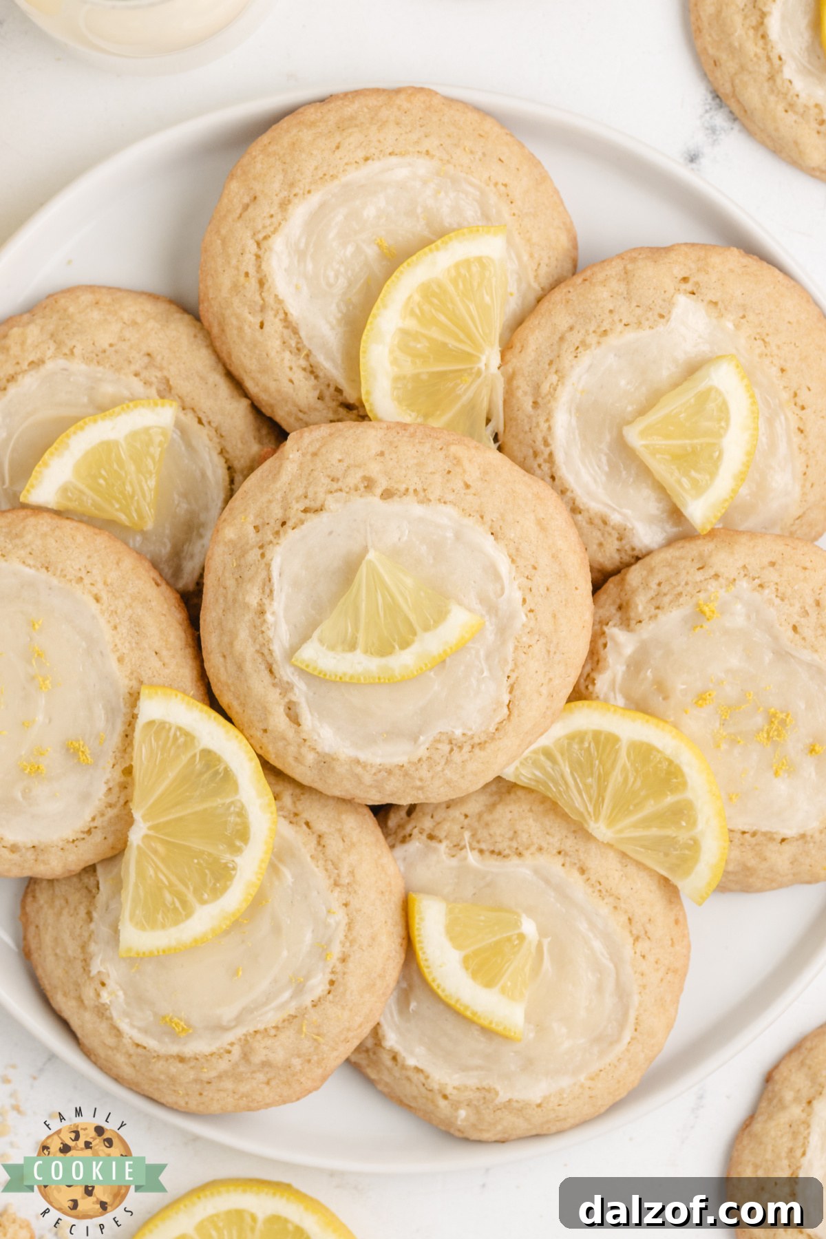 A plate of lemon cheesecake cookies showing the cream cheese topping on golden lemon cookies.