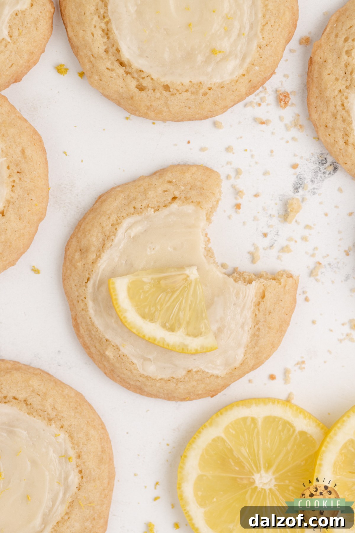 Close-up of a lemon cheesecake cookie showing the creamy white cheesecake topping against the golden lemon dough.