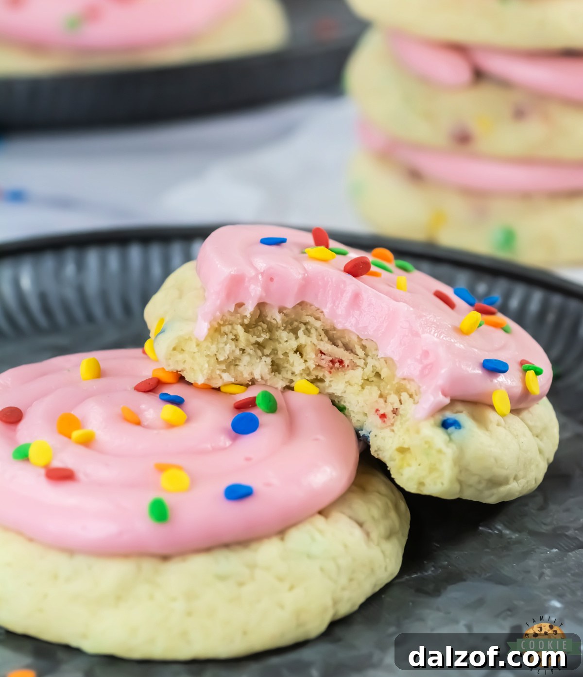 A copycat Crumbl confetti cake cookie broken in half showing the soft interior with sequin sprinkles throughout