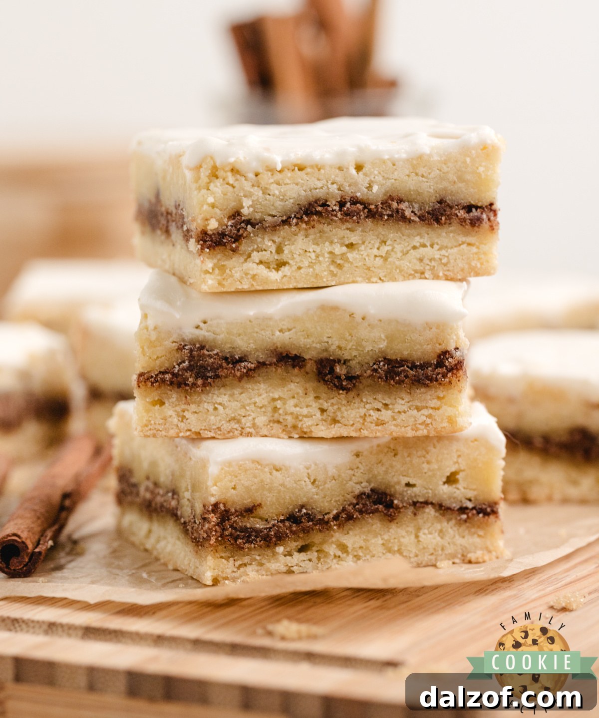 Cinnamon roll sugar cookie bars cut into squares showing the brown sugar cinnamon layer and cream cheese frosting on top